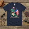 How Ridiculous T-Shirt featuring a cartoon T-Rex dinosaur wearing a patriotic hat and sunglasses, holding an American flag