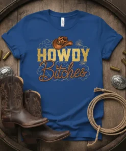Blue t-shirt with "HOWDY Bitches" text in gold and rope design, featuring a cowboy hat graphic