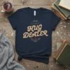 Hug Dealer text design with heart hands and wings graphic on a navy t-shirt