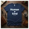Navy blue t-shirt with white text "Human Kind Be Both" printed in a clean, modern font