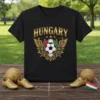 Black t-shirt with "HUNGARY" in gold lettering above a soccer ball crest with Hungarian flag colors and gold wings