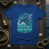 Blue t-shirt with a blue whale breaching through waves, text reads "Hurtin' For A Squirtin" in decorative font