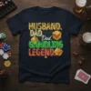 Husband Dad Gambling Legend t-shirt with dice and casino chip graphics. Features bold text in yellow, green, and orange
