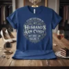 Blue t-shirt with gold and white text reading "It's Not Easy Being My Husband's Arm Candy But Here I Am