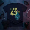 I AM 43+ text with a retro futuristic cyborg middle finger graphic on a black t-shirt