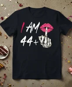 Black t-shirt with white text "I AM 44+" and a graphic of sparkly pink lips with a finger shushing gesture