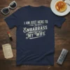 Navy blue t-shirt with distressed white text "I AM JUST HERE TO EMBARRASS MY WIFE" in a playful font