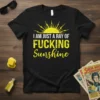 Black t-shirt with "I AM JUST A RAY OF FUCKING Sunshine" in bold yellow and white distressed typography, featuring a