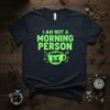 I am not a morning person t-shirt with a grumpy green coffee cup graphic and zzz symbols