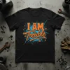 I AM Trouble text design in orange and blue on a black t-shirt, with a distressed splatter background