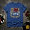 Blue t-shirt with "I ARIANA" text, a decorative red heart, and musical notes in a vintage gold frame