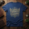 I BAIDASS BADASS Grandma text with golden wings and ornate filigree design on a navy blue t-shirt