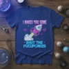 I BAKED YOU SOME SHUT THE FUCUPCAKES text on a blue t-shirt with a retro rocket graphic