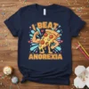Navy t-shirt with bold orange text "I BEAT ANOREXIA" and a cartoon pizza slice flexing its biceps