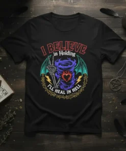 Black t-shirt with gothic design: "I BELIEVE in Holding I'LL HEAL IN HELL" quote, skeleton hand, tornado, heart, and wings