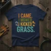 I Came I Mowed I Kicked Grass text design with lawn mower and boot graphics on a navy t-shirt