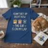 T-shirt with text "I Can't Get Up Right Now The Cat Is On My Lap" and paw print graphics
