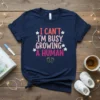 Navy blue t-shirt with "I Can't I'm Busy Growing A Human" text in pink and red, decorated with small white
