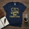 Navy t-shirt with gold glitter text that reads "I Can't But I Know a Guy," featuring a decorative crown graphic