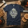 Navy t-shirt with white text "I CANT. I'M BUSY. CUTTING TREES" and graphics of trees and axes