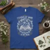 I Closed My Book To Be Here quote on a royal blue t-shirt with a circular floral design around an