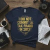 T-shirt with gold text "I DID NOT COMMIT TAX FRAUD IN 2013" and subtle financial graphics, dark navy blue fabric