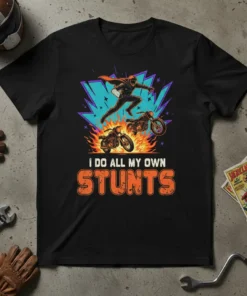 Black t-shirt with "I DO ALL MY OWN STUNTS" text and graphic of a superhero-style motorcycle rider jumping over two