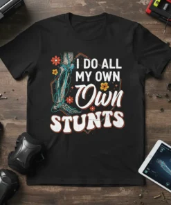 Skeleton graphic t-shirt with the text "I Do All My Own Stunts" in retro font, surrounded by flowers