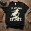 Black t-shirt with white distressed text "I DO MY OWN STUNTS" above a silhouette of a horse rearing over a