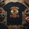 I Do My Own Stunts motocross t-shirt with a rider performing a stunt against a retro sunset background