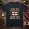 I Don't Need Therapy I Just Need To Go To England text with English flag graphic on a navy t-shirt