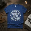 "I Don't Work Here Anymore" quote in distressed white text on a blue t-shirt, framed by gears and bolts