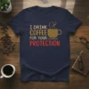 I DRINK COFFEE FOR YOUR PROTECTION text design with a coffee cup graphic, navy t-shirt