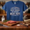 I Enjoy Romantic Walks Through the Meat Dept quote on a blue t-shirt with crossed cleavers and a cow graphic