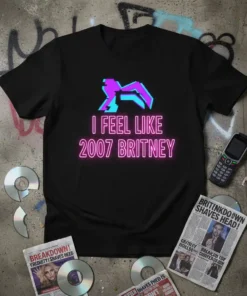 Black t-shirt with "I Feel Like 2007 Britney" in neon pink text and a glitchy purple icon graphic