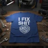 Blue t-shirt with white text "I FIX SHIT" above a shield graphic of tools and gears