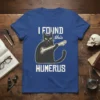 Black cat holding a bone with text "I FOUND this HUMERUS" on a blue t-shirt