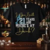 Black t-shirt with "I Gave Birth 21 Years Ago WHERE'S MY Drink?" text, featuring a champagne glass graphic and gold