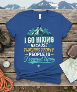 I Go Hiking Because Punching People Is Frowned Upon quote on a blue t-shirt with mountain graphics