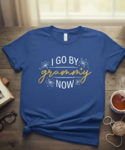 I Go By Grammy Now text design with floral accents on a blue t-shirt, perfect for grandmothers
