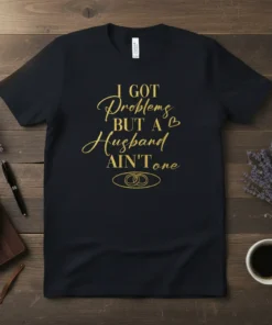 Black t-shirt with gold glitter text "I GOT Problems BUT A Husband AIN'T one" and wedding rings graphic