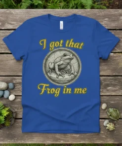Blue t-shirt with yellow text "I got that Frog in me" and a detailed circular graphic of a frog
