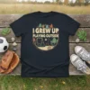 I Grew Up Playing Outside text with vintage playground graphic on a navy t-shirt
