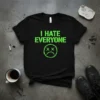 Black t-shirt with bright green distressed text "I HATE EVERYONE" and a sad face graphic with X eyes