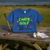 Blue t-shirt with "I HATE GOLF" in neon green, surrounded by flaming golf balls, clubs, and a golf cart