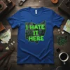 Blue t-shirt featuring the phrase "I HATE IT HERE" inside a cracked Ohio state outline in neon green