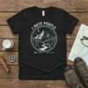 Black t-shirt with "I Hate People" text above a circular graphic of mountains, trees, and a tent under a crescent
