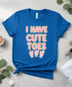 Blue t-shirt with the text "I HAVE CUTE TOES" in pink and yellow, featuring cartoon baby feet with crowns and