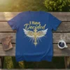 Blue t-shirt with gold text "I Have Decided" above a golden cross with wings design