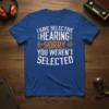 I HAVE SELECTIVE HEARING SORRY YOU WEREN'T SELECTED text design on a blue t-shirt with white and orange distressed typography